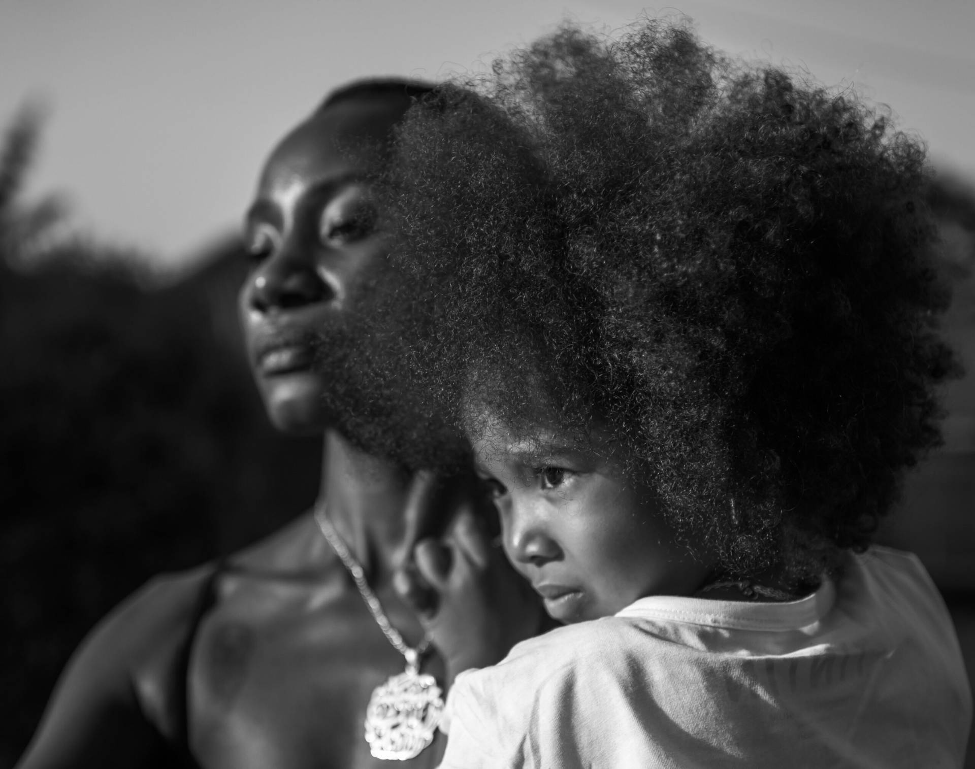 A competitive young girl gymnast and her mother standing strong and confident together at a gymnastics arena